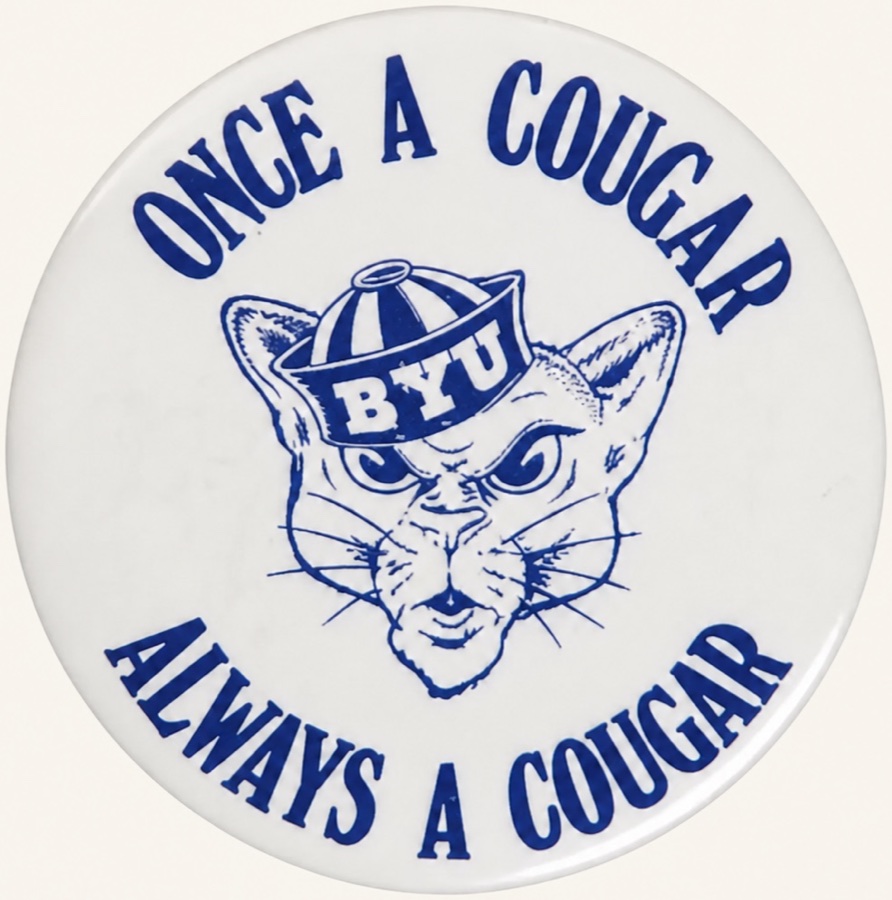 A white pinback button printed in blue with the BYU cougar mascot, reading Once a Cougar, Always a Cougar.