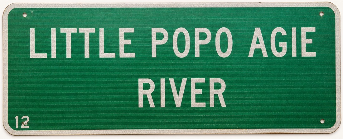 Green road sign reading Little Popo Agie River.